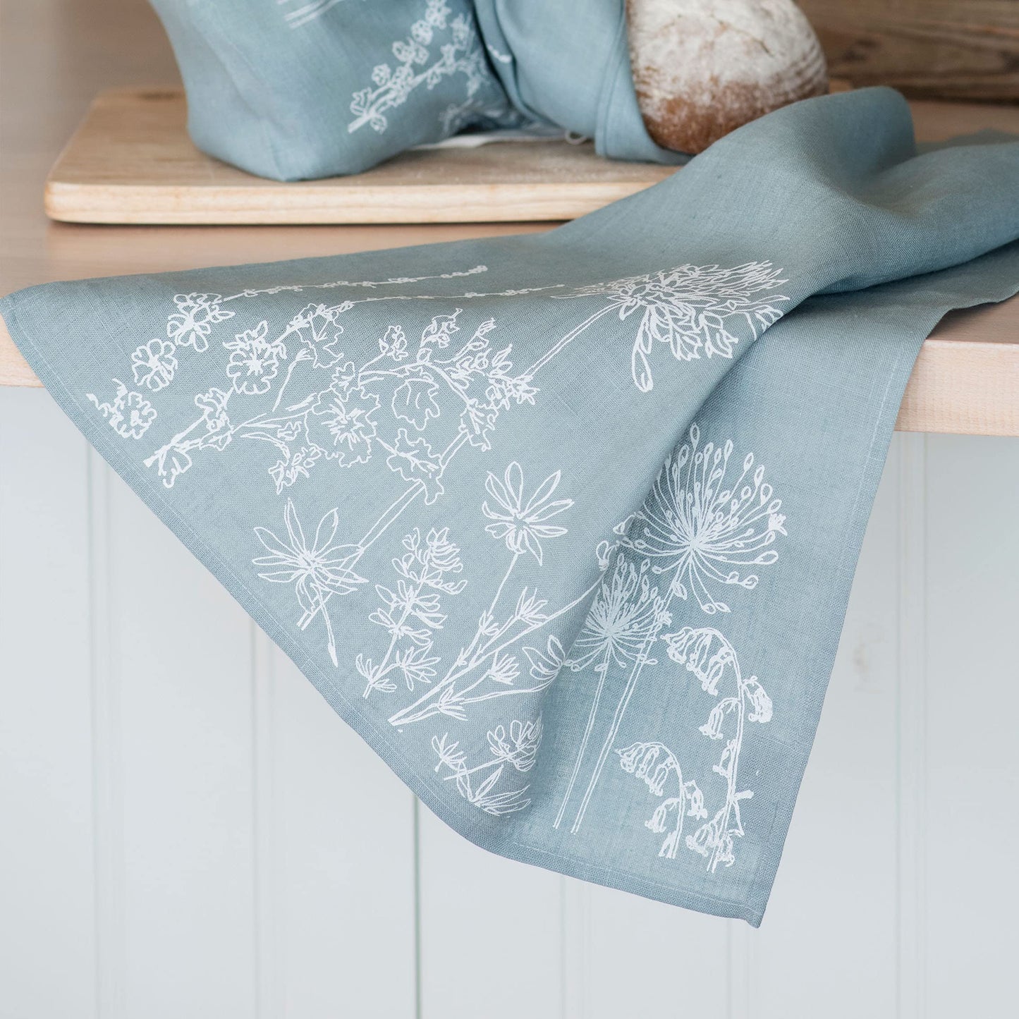 Helen Round Linen Tea Towel, duck egg blue. This beautiful, hand printed towel features garden flowers. Machine Washable at 40 degrees and will
